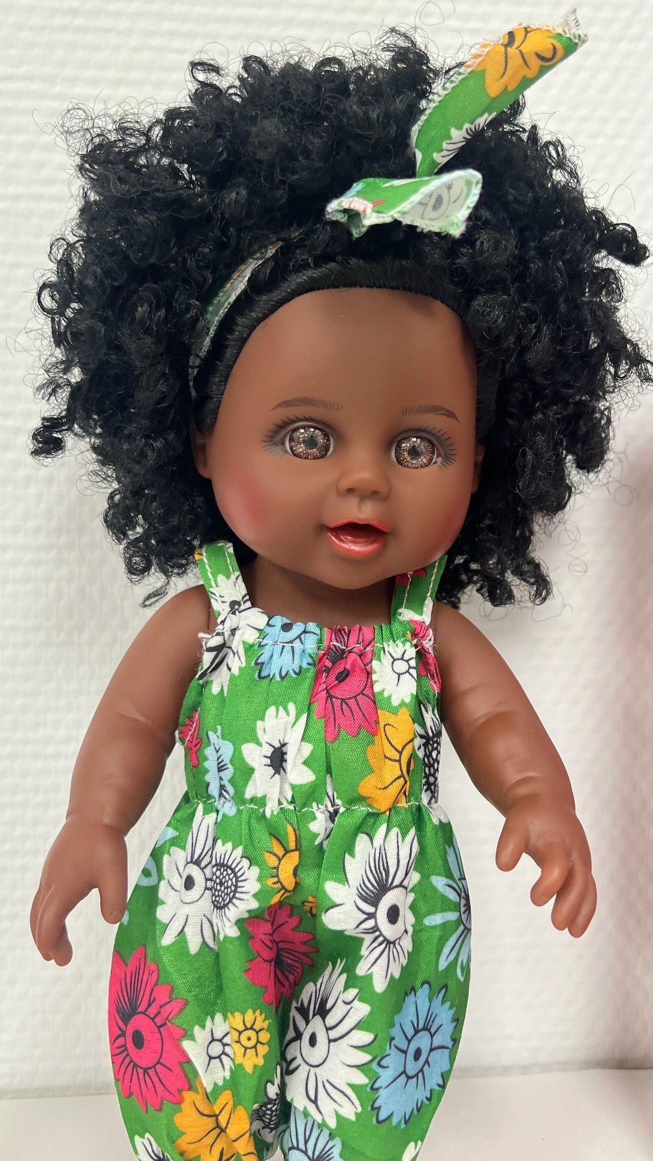 Poupée Aïcha – Poupée noire aux cheveux bouclés avec tenue fleurie verte (mesure 25 cm)